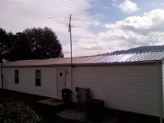 New metal roof on a single wide mobile home with a TV antenna in Larchwood